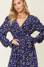 A Close-up photo of model wearing a  navy Flounce & Tie Midi dress styled with jewelry.