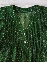 Close-up of neckline slit and buttons on dark green EverDot Flutter Top.
