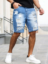 Side view pocket detail on men's blue ripped text logo printed denim shorts.