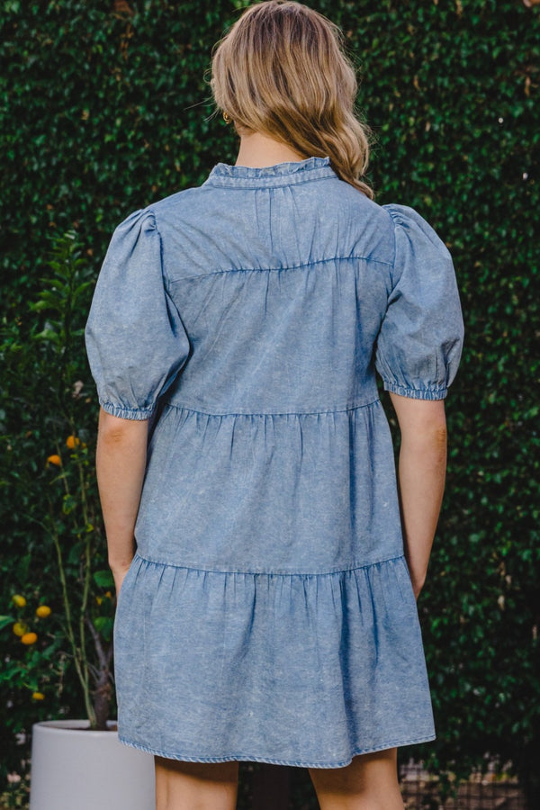 Back view of model in ODDI Washed Tiered Mini Denim Dress showcasing tiered silhouette and lightweight washed denim fabric.