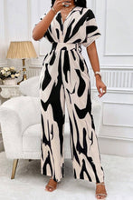Model wearing Black Oléavia Luxe Jumpsuit styled with gold hoops and strappy heels for a chic dinner party.