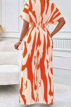 Close-up of the back neck button detail and wide-leg flow in Orange.