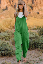 Model wearing Onvaira V-neck sleeveless jumpsuit front view in Green.