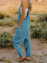Model in Onvaira V-neck sleeveless jumpsuit side view showing relaxed fit and pocket detail in Azure.