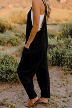 Model in Onvaira V-neck sleeveless jumpsuit side view showing relaxed fit and pocket detail in black.