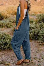 Model in Onvaira V-neck sleeveless jumpsuit side view showing relaxed fit and pocket detail in peacock blue.