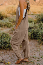 Model in Onvaira V-neck sleeveless jumpsuit side view showing relaxed fit and pocket detail in tan.