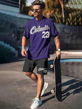Model wearing a oversized purple Orrik 3D Printed Motion Set with 'Columbia 23' text on purple round neck tee and black shorts with the number 'Columbia 23' on them.
