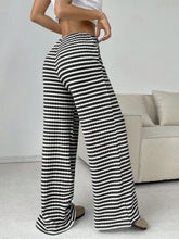 Back view of Black Orvella LumaTide Striped Wide Leg Pants styled with a grey short-sleeved blouse, jewelry, and camel loafers.