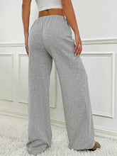 Back view of Grey Orvella LumaTide Striped Wide Leg Pants styled with a white short-sleeved blouse, jewelry, and camel loafers.