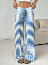 Lifestyle image featuring Light Blue Orvella LumaTide Striped Wide Leg Pants styled for casual weekends with a white blouse and camel boots.