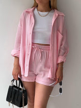 Close-up of blush pink fabric texture and button details.