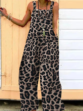 Model in Panthorlisa Leopard Overalls styled with sandals and straw hat at a beachside café.