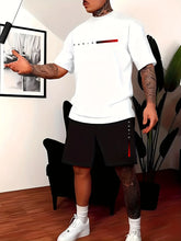 Person wearing the ivory Parivor FutureFlex Set-a white t-shirt with red accents and black shorts in an indoor setting.