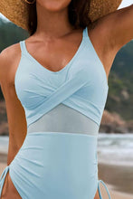 Pastel blue drawstring ruched V-neck one-piece swimwear front view styled with straw hat close up