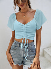 Side view of Glowflutter Crop Top in pastel blue showing sheer sleeve texture and cropped silhouette.