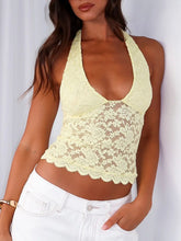 Model wearing pastel yellow Seraphinelli Lace Halter Blouse with backless silhouette and floral lace.