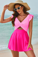Side view of model wearing pink cutout V-neck cap sleeve swim dress showing ruched front and plunge back design