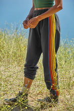 side view of person walking in grassy field wearing gray PrismFlow Active Pants