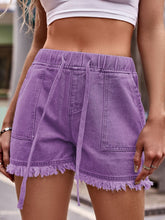Model in purple Viretta™ raw hem shorts styled for a festival look with a crop top.