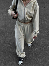 Model walking to departure gate in QeNora Zip & Pocket Set apricot