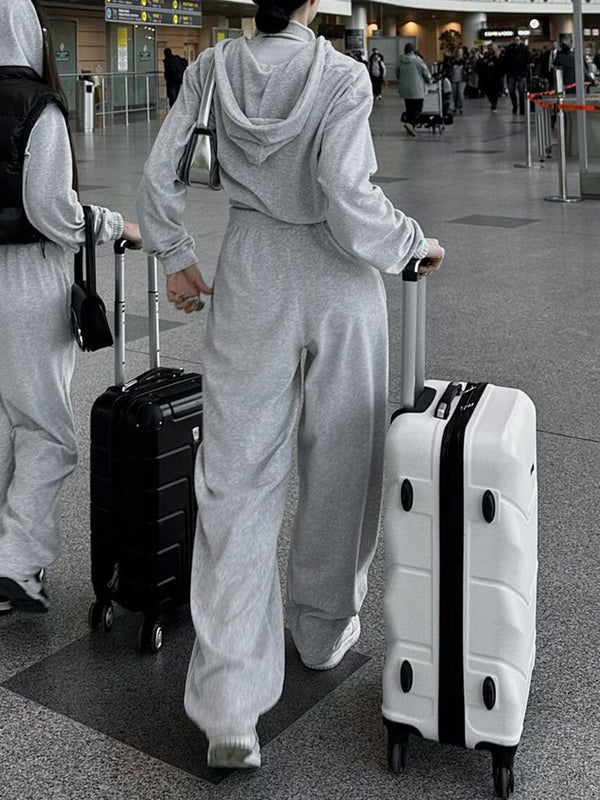 Back view of QeNora Zip & Pocket Set Light Gray with luggage at airport