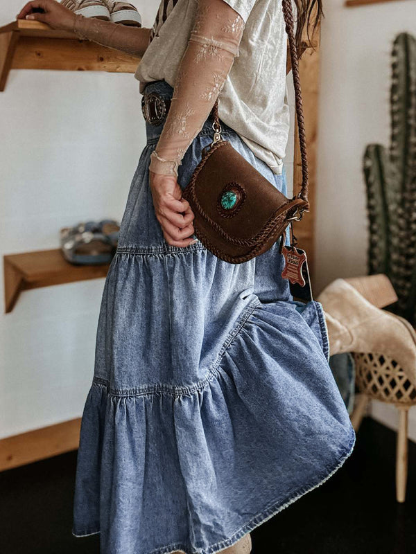Side view of Raventa Tiered Denim Skirt showcasing button-fly and ruffled hem