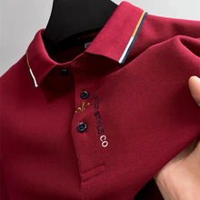 Zoomed in front view of red Royale Crest Fleur de Lis Polo showing quality fabric texture.