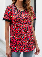 Side view of red leopard print round neck short sleeve tee, showing the relaxed fit and lightweight fabric draping naturally at the hip.