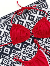 Close-up flat lay detail of red frill trim halter neck bikini set showing adjustable tie strings and frill trim detail