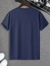 Regal K Bear Navy Blue Graphic Tee back view on hanger with white sneakers.