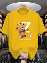 Regal K Bear Yellow Graphic Tee on hanger in luxury closet.
