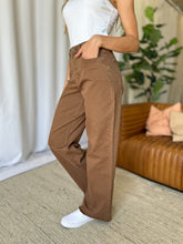  Model left side view with hands in pockets highlighting pocket functionality of RFM High Rise Jeans.