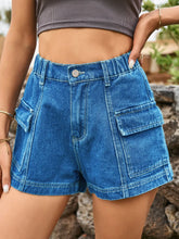 Woman in a patterned blouse and royal blue Joyful Journey Denim shorts exploring a new city.