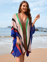Model wearing royal blue openwork color block plunge cover-up with deep V-neckline at beachside setting