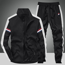 Front view of the Black Royale Flux Crownstripe 2 Piece Tracksuit by NyxeAura Royale, featuring full-zip stand-collar jacket, contrast side stripes, pockets, and red-white-navy pants logo.