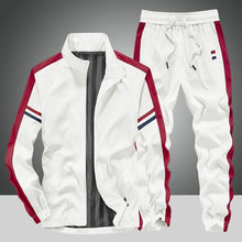 Front view of the White Royale Flux Crownstripe 2 Piece Tracksuit by NyxeAura Royale, featuring full-zip stand-collar jacket, contrast side stripes, pockets, and red-white-navy pants logo.
