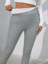 Close-up of embroidered logo on Royale Reflect Elevé Gray Leggings waistband.