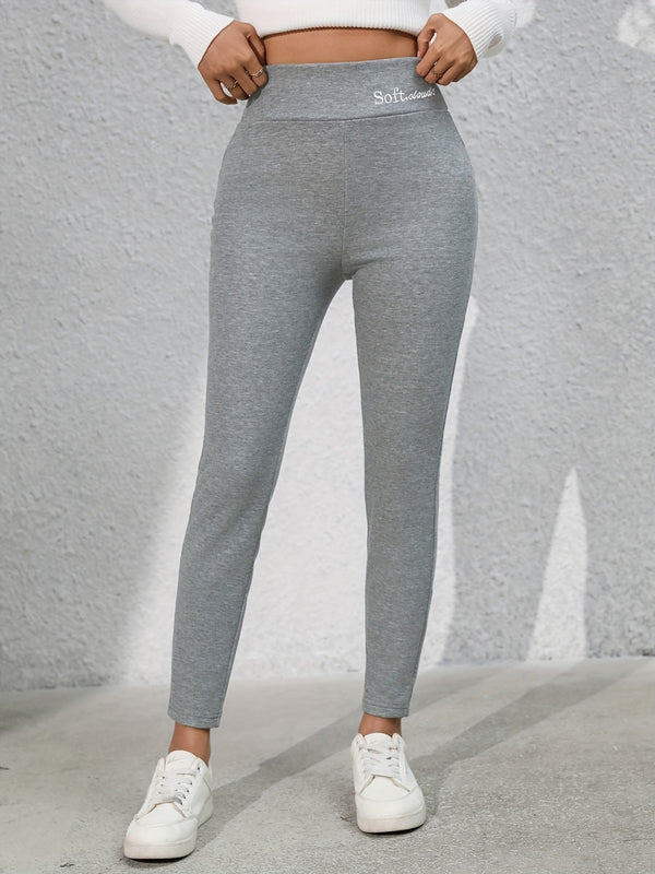 Model wearing Royale Reflect Elevé Gray Leggings, front view showcasing embroidered waistband.