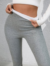 Model relaxing at home in Royale Reflect Elevé Gray Leggings with cozy hoodie.