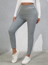 Model cycling indoors in Royale Reflect Elevé Gray Leggings and active tank.