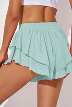 Side profile of Ruffira Flow Active Shorts in Aqua with layered silhouette.