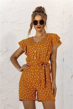Woman enjoying coffee in Ruffled Polka Dot Half Button Romper - Mustard, Relaxed Lifestyle Wear.