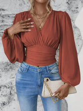 Model styled in rust Balloonique™ Blouse with accessories for a complete look.