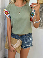 Model styled in sage CrochetCharm Top with shorts, sandals, a tan straw purse, and accessories for a complete look.