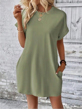 Woman attending a weekend rooftop mixer in Sage Rahluna Mini Tee Dress styled with statement earrings and chunky sandals.
