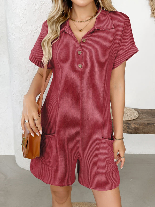 Woman wearing scarlet short sleeve romper, front view, smiling outdoors.
