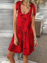 Model in scarlet Kélure overalls sipping iced coffee at a cafe patio, styled with a graphic tee and white sneakers.