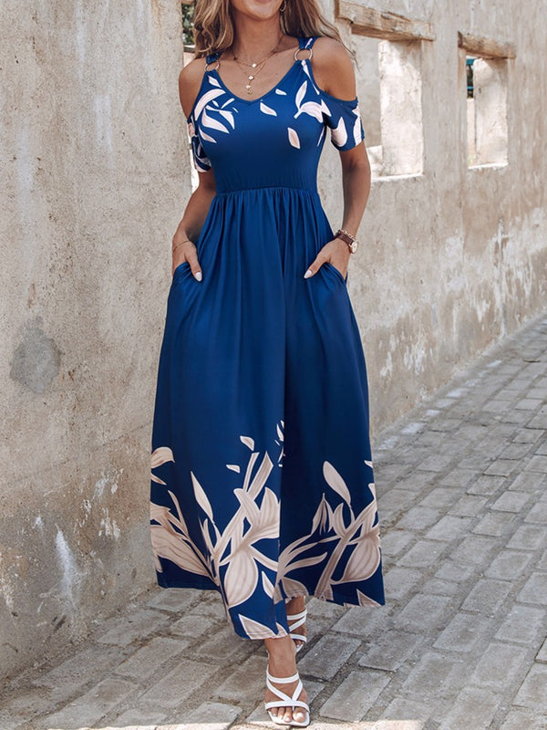 Model posing with her hands in the pockets of the Navy Blue Serene Xymeraeh™ Cold Shoulder Maxi Dress, styled with layered gold jewelry and tan heels for a relaxed brunch look.