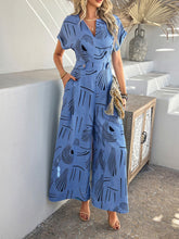 Model wearing Serenoor jumpsuit in blue with tan clutch and jewelry, posing at a beach house, close-up view.